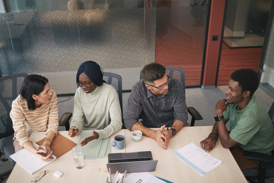 Cross-functional development team discussing project priorities in a collaborative office meeting.