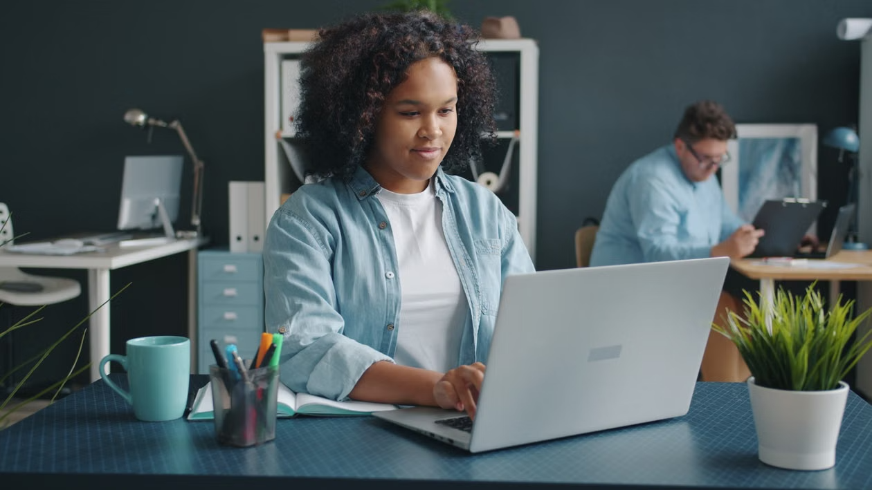 Professional using a laptop in an office, representing enterprise AI maturity, governed AI adoption and production-ready AI systems.