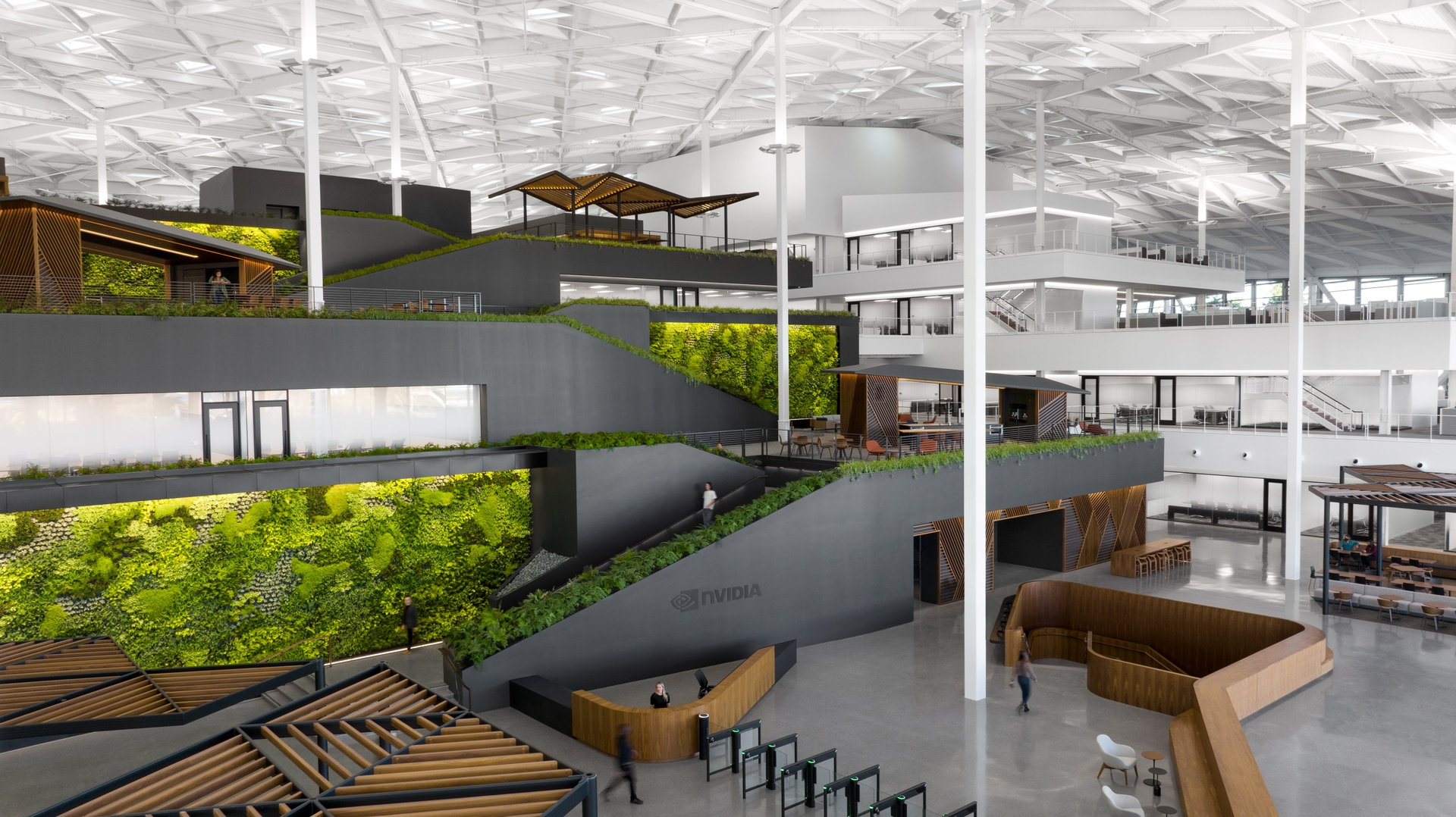 Interior of NVIDIA’s Voyager headquarters in Santa Clara, California, featuring multi-level workspaces, green living walls, stairways, meeting areas, and an NVIDIA reception desk.