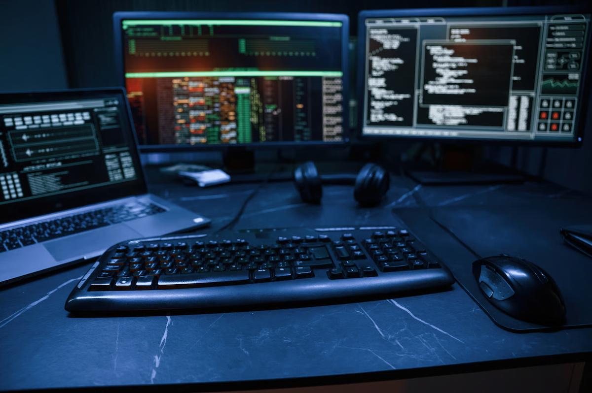 Developer workstation with code and system-monitoring screens, illustrating AI-assisted software engineering and production reliability.