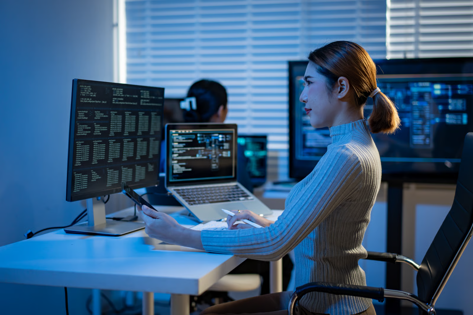 Data engineer reviewing data structures and an architecture diagram across a monitor and laptop, illustrating how semantic layers fit into enterprise AI architecture