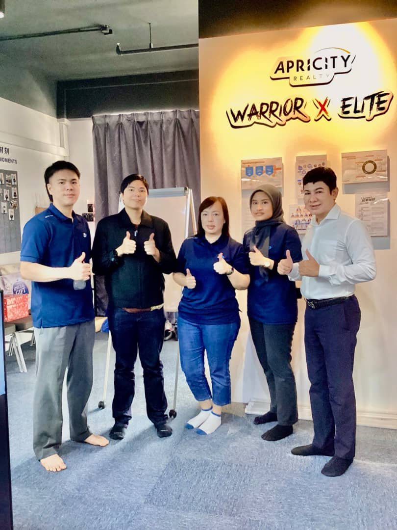 Debaters with thumbs up at the Warrior x Elite wall