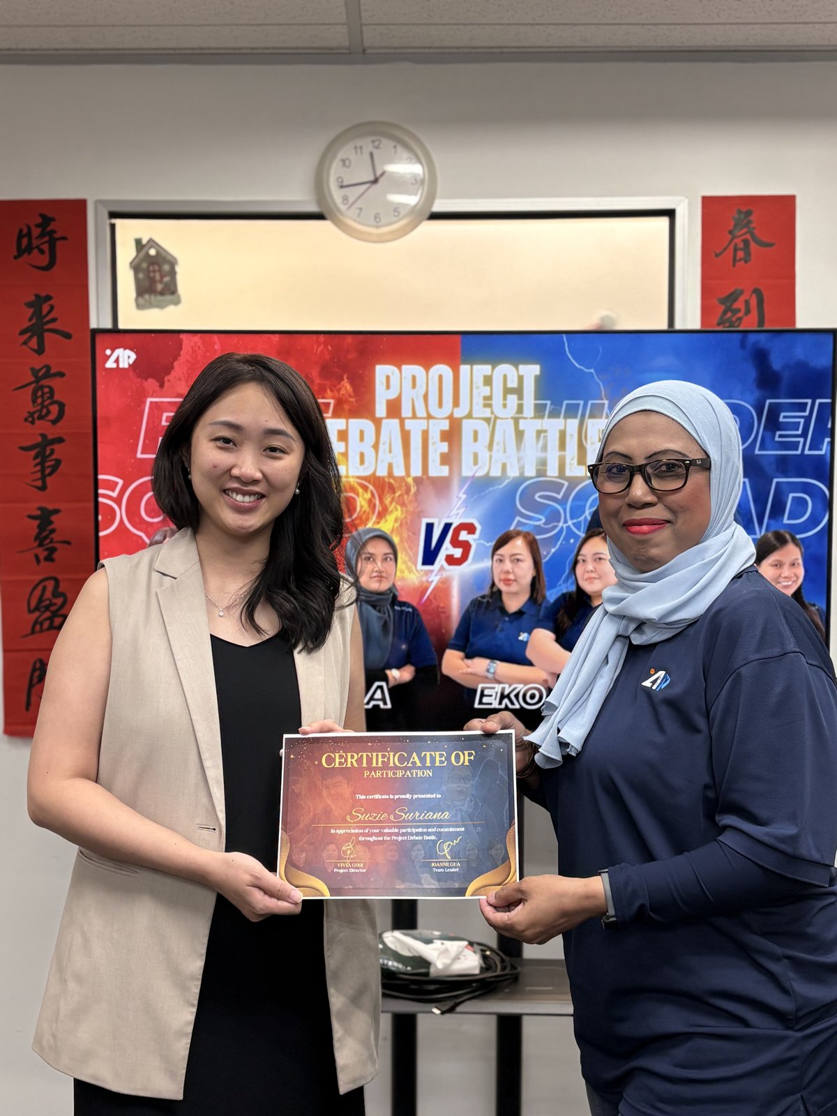 A debater receiving her certificate in front of the Project Debate Battle backdrop
