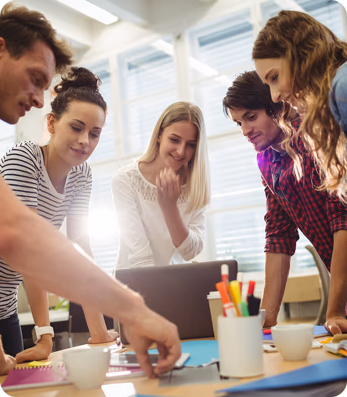 A group of people gathered around a laptop.