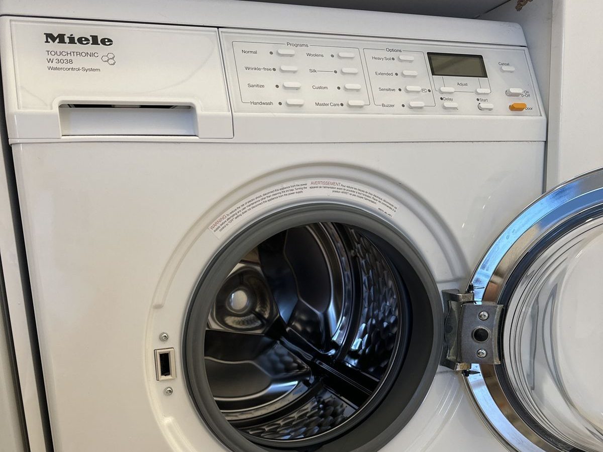 Miele W3038 compact washer with door open during service in a NYC apartment