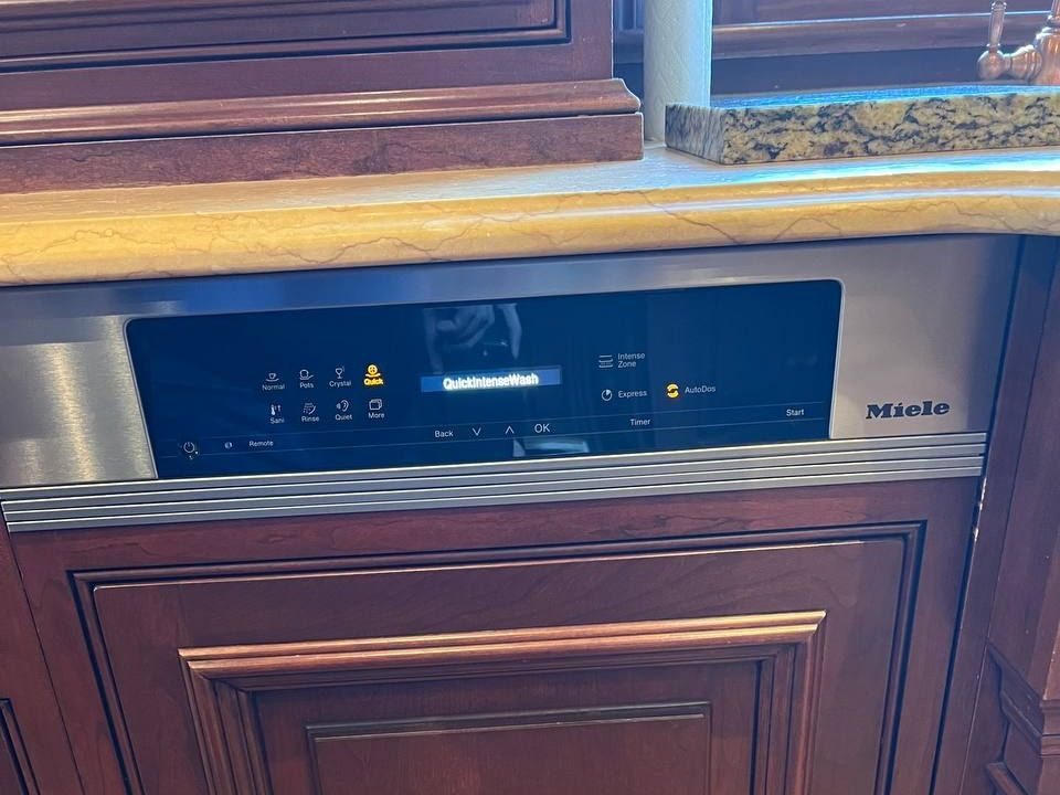Miele dishwasher built into wood cabinetry in a NYC apartment kitchen