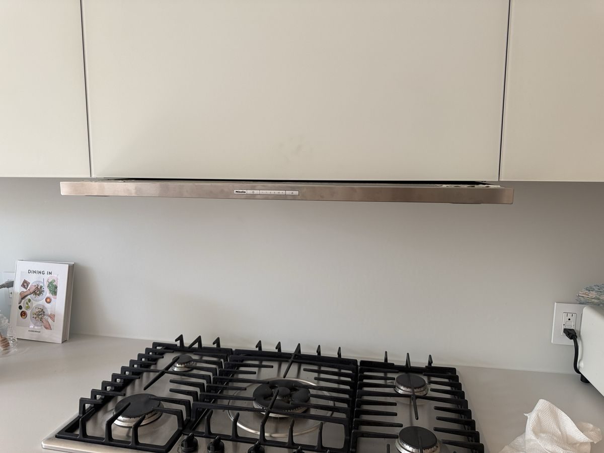 Miele slide-out range hood above a gas cooktop in a NYC kitchen