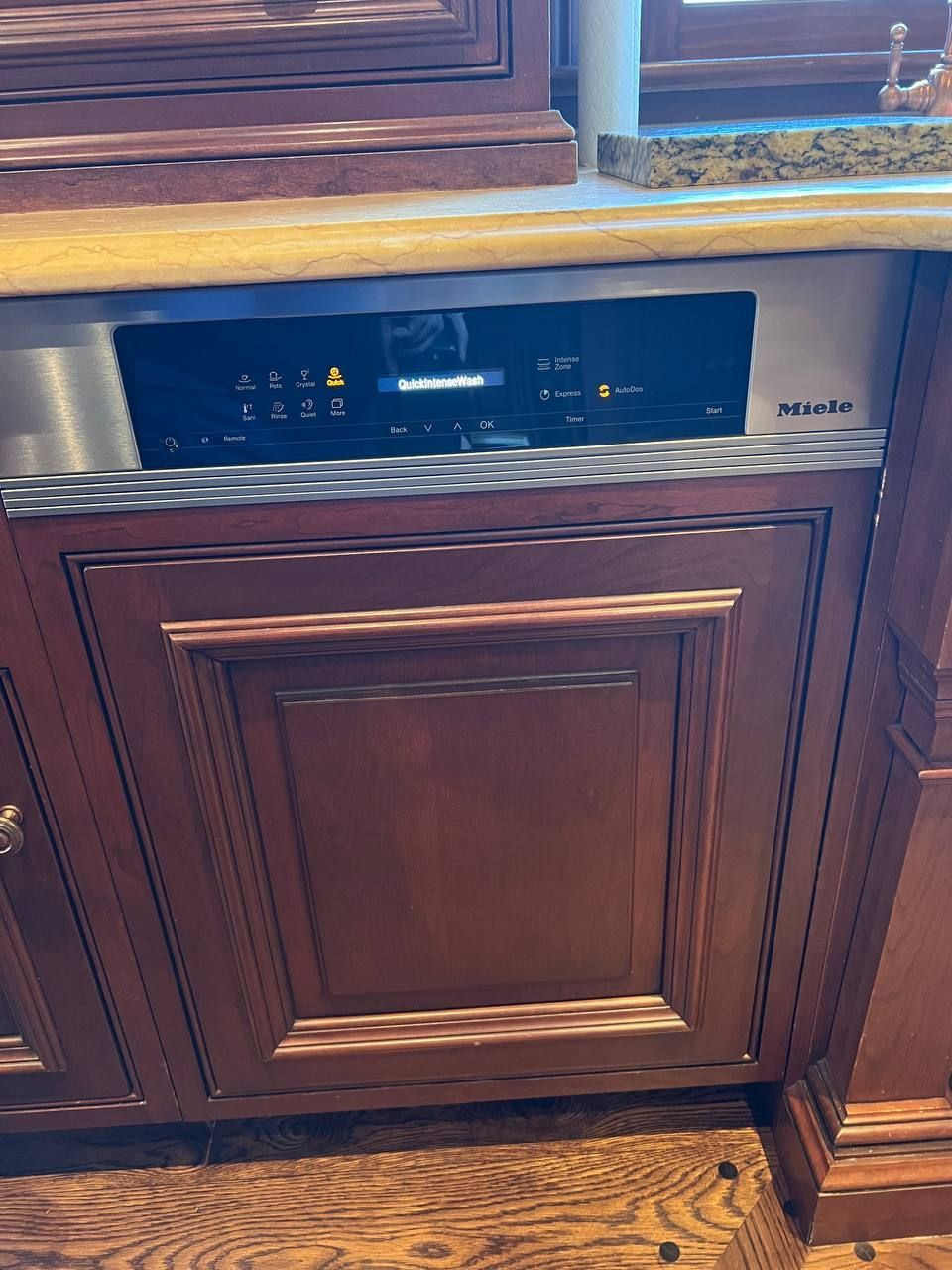 Miele panel-ready dishwasher built into wood cabinetry in a NYC apartment kitchen