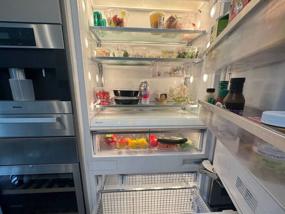 Miele built-in refrigerator beside coffee machine and wine storage in an NYC kitchen