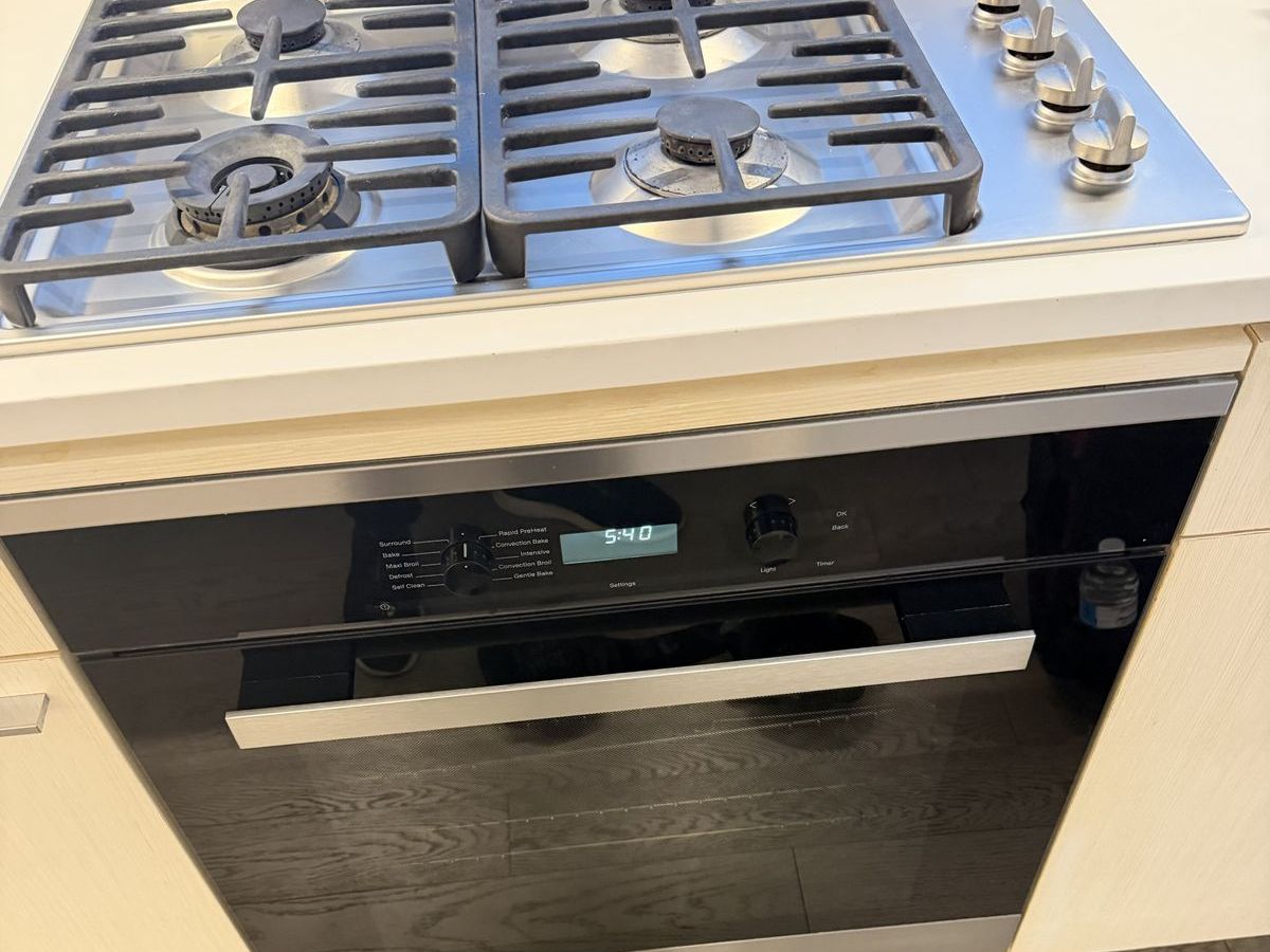 Miele H-series wall oven built in under a gas cooktop in an NYC apartment