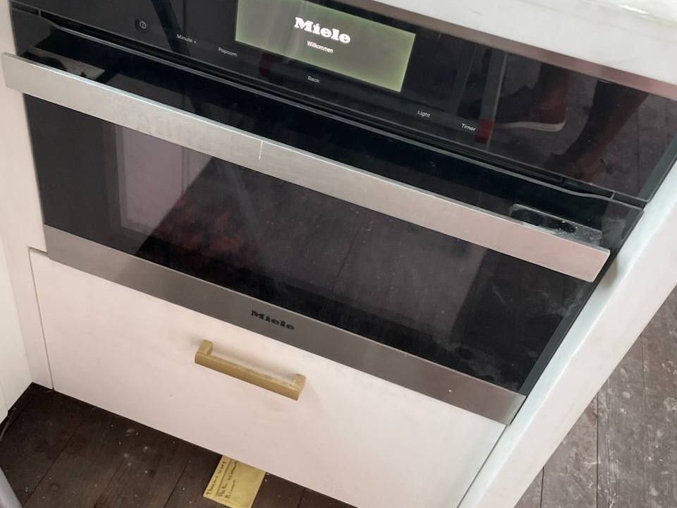 Miele combination speed oven above a warming drawer in white cabinetry