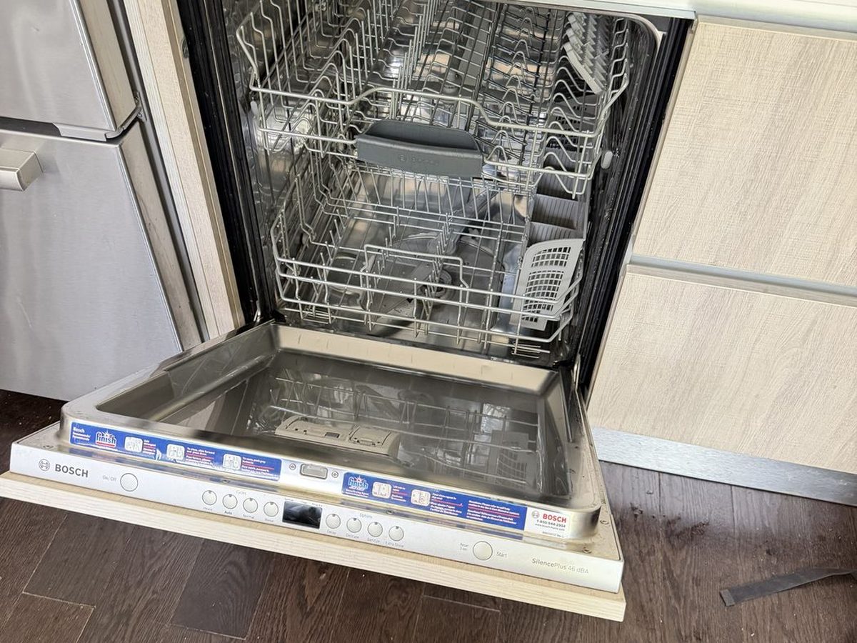 Older Bosch dishwasher with the door open during service