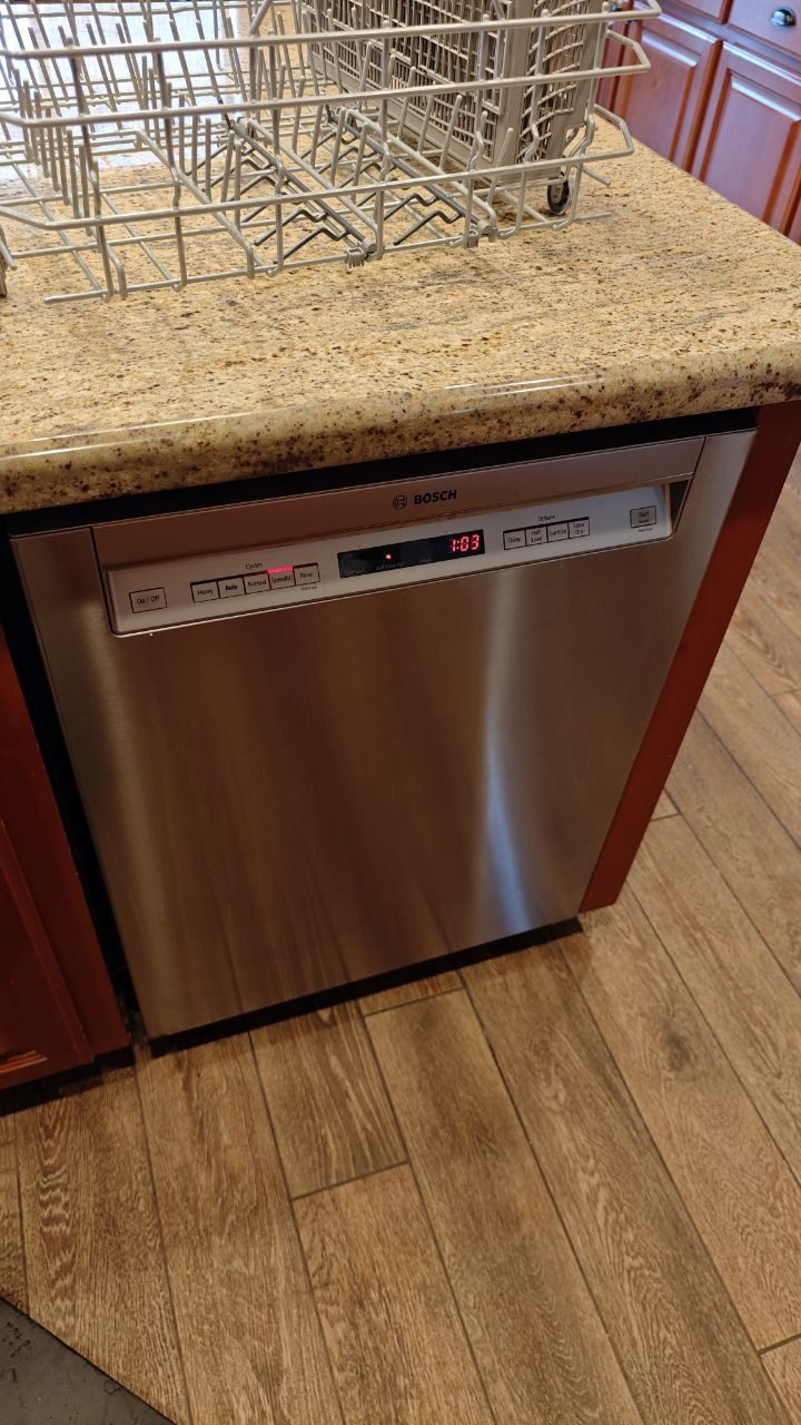 Bosch dishwasher during service with racks pulled out onto the counter