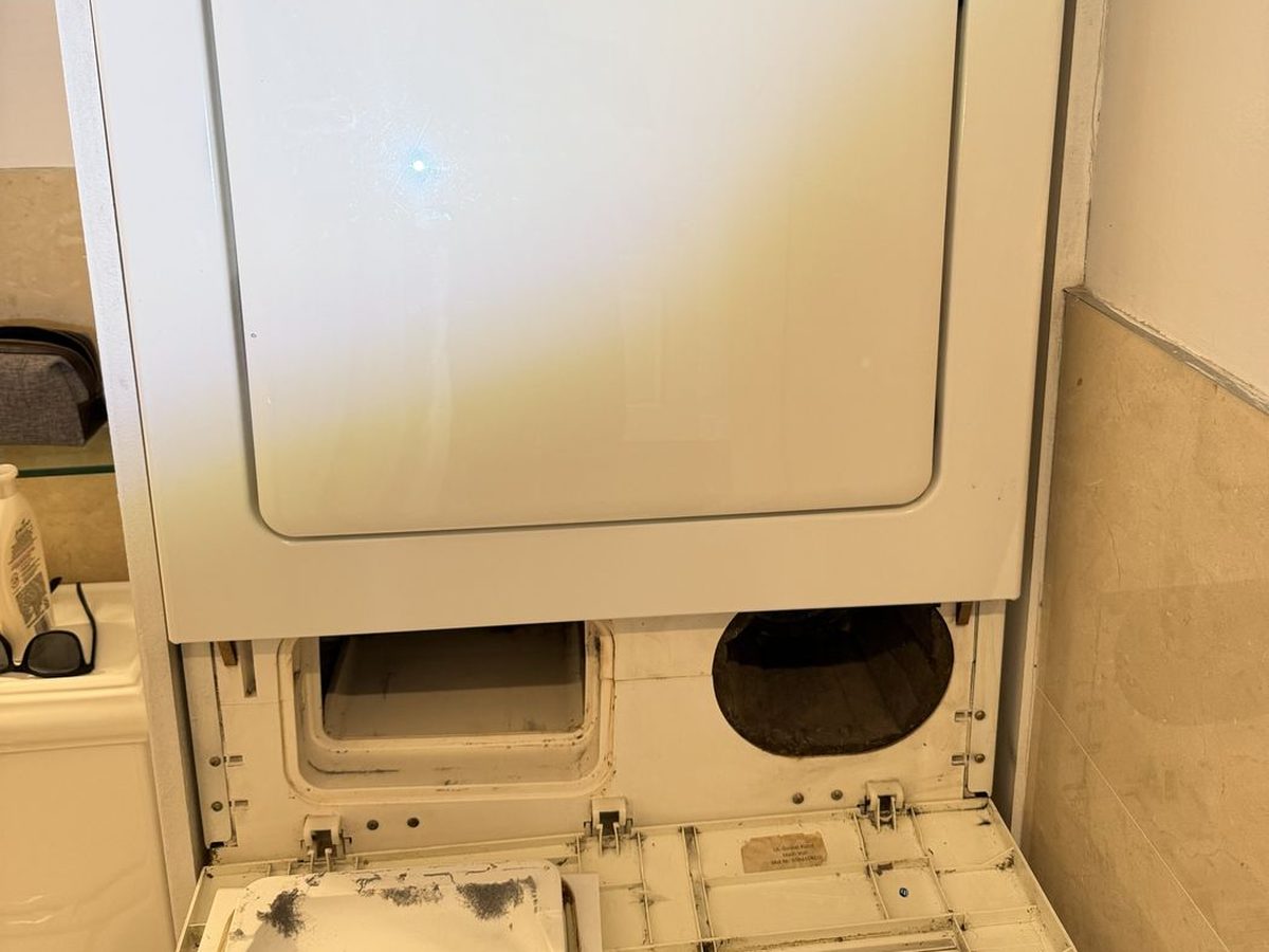 Bosch stacked dryer with the lower access panel open during condensate service