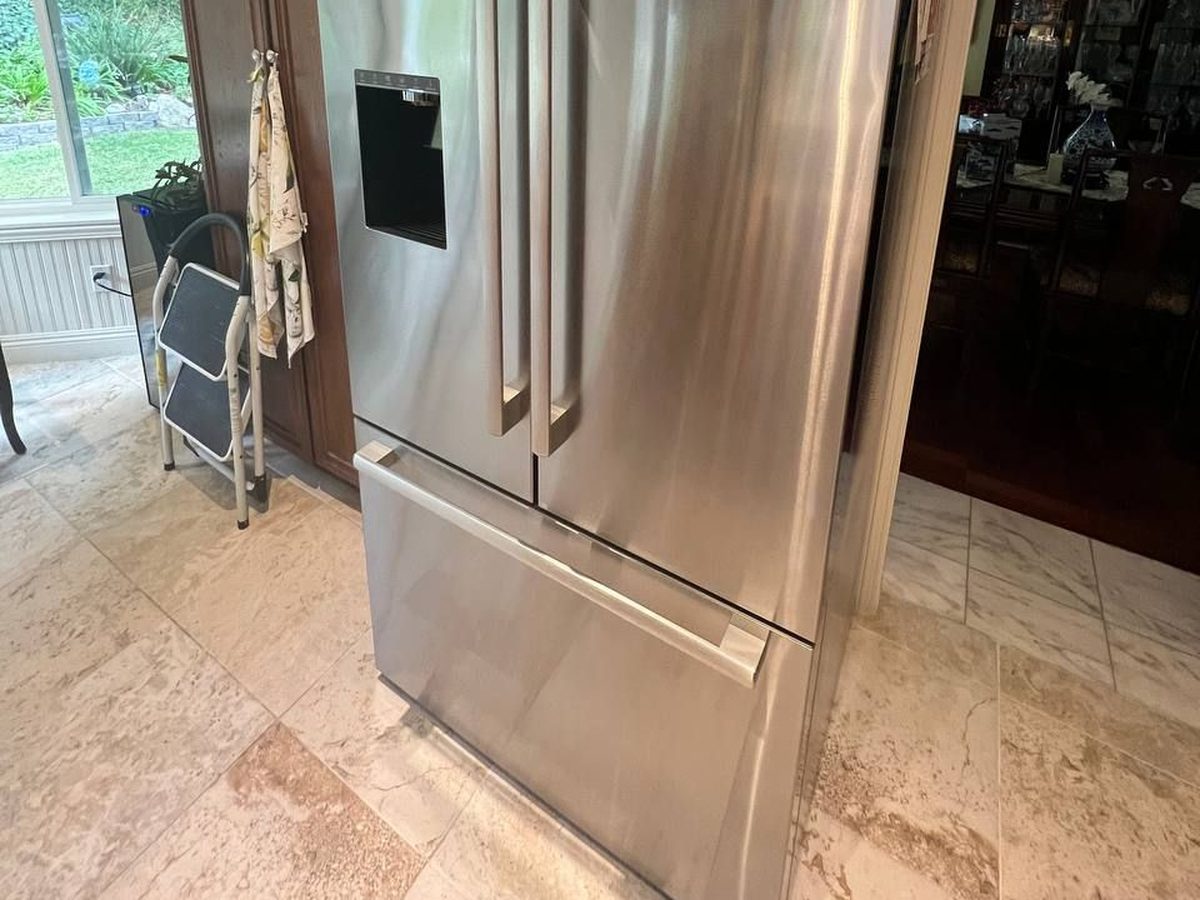 Bosch refrigerator in an NYC apartment kitchen with stone floors