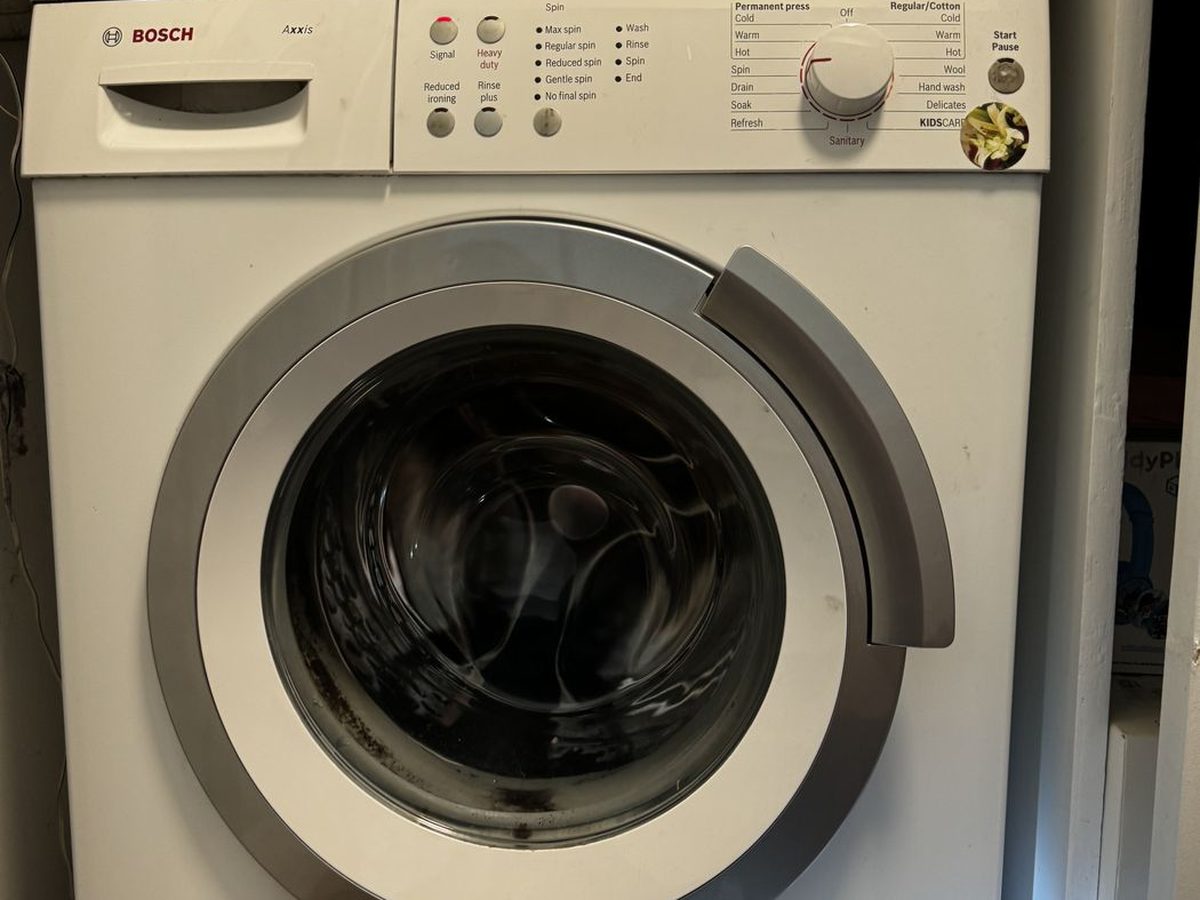 Bosch Axxis washer control panel and drum in a stacked laundry closet