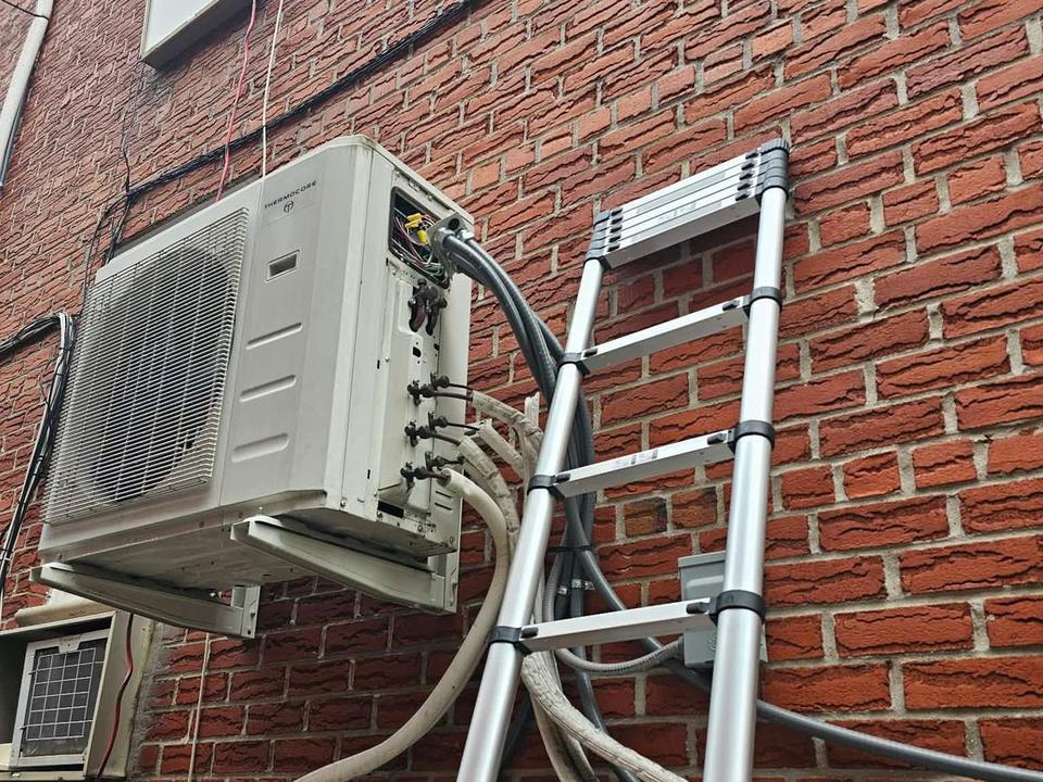 Multi-split outdoor unit on a Brooklyn brick wall during a service visit