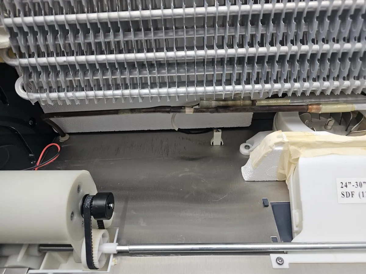 Evaporator coil and drive parts inside a classic Sub-Zero during service
