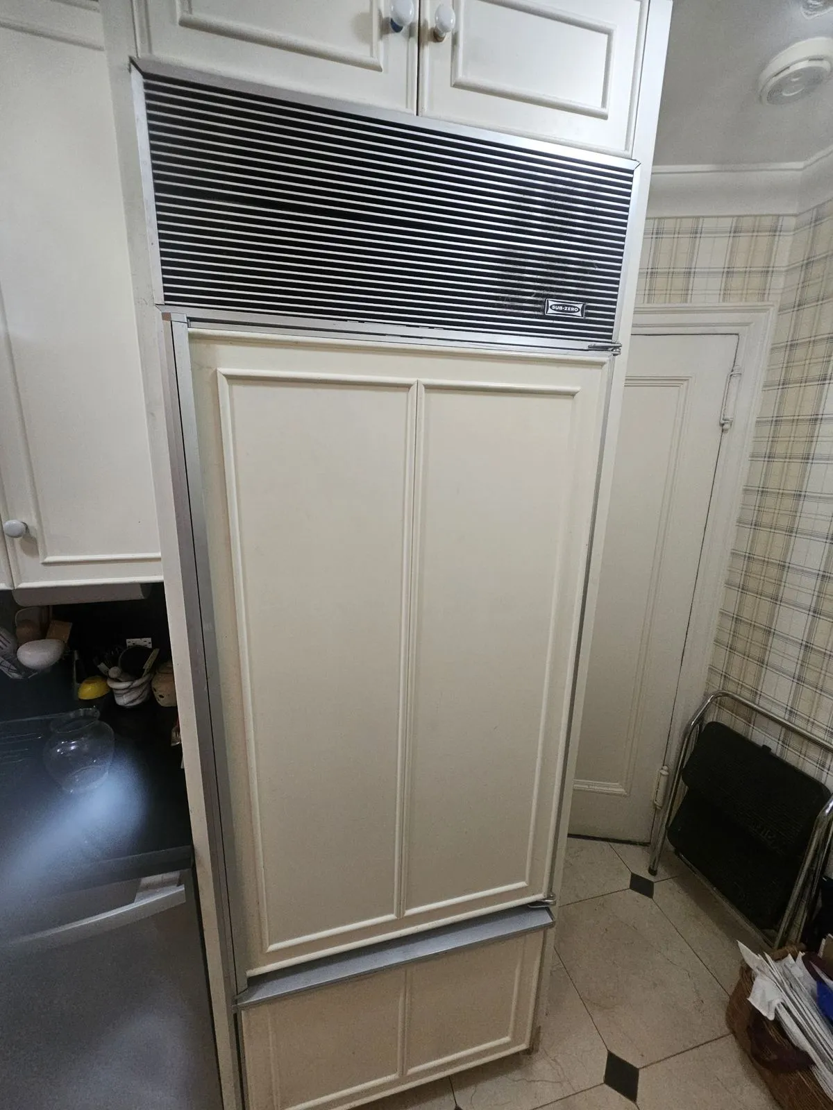 White panel-front Sub-Zero built-in refrigerator with the classic louvered grille in a NYC kitchen
