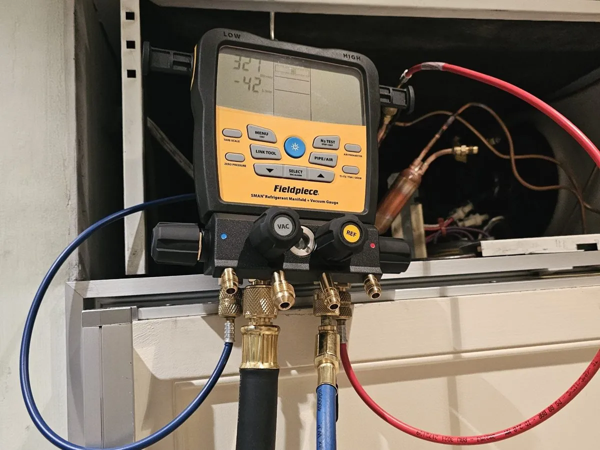 Digital manifold gauges connected to a built-in Sub-Zero during sealed-system diagnosis