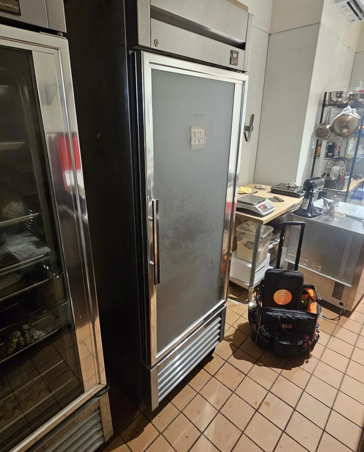 Commercial reach-in refrigerator during a service visit in an NYC restaurant kitchen