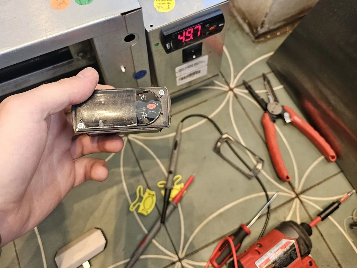Technician diagnosing a commercial refrigeration temperature controller on site in NYC