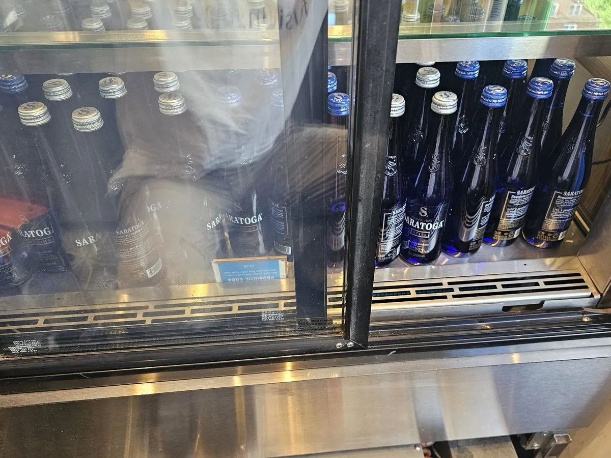 Glass-door back bar refrigerator stocked with bottled drinks in an NYC bar