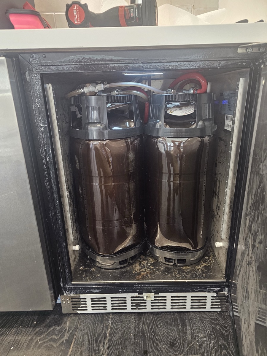 Two beer kegs with lines inside an undercounter kegerator at an NYC bar