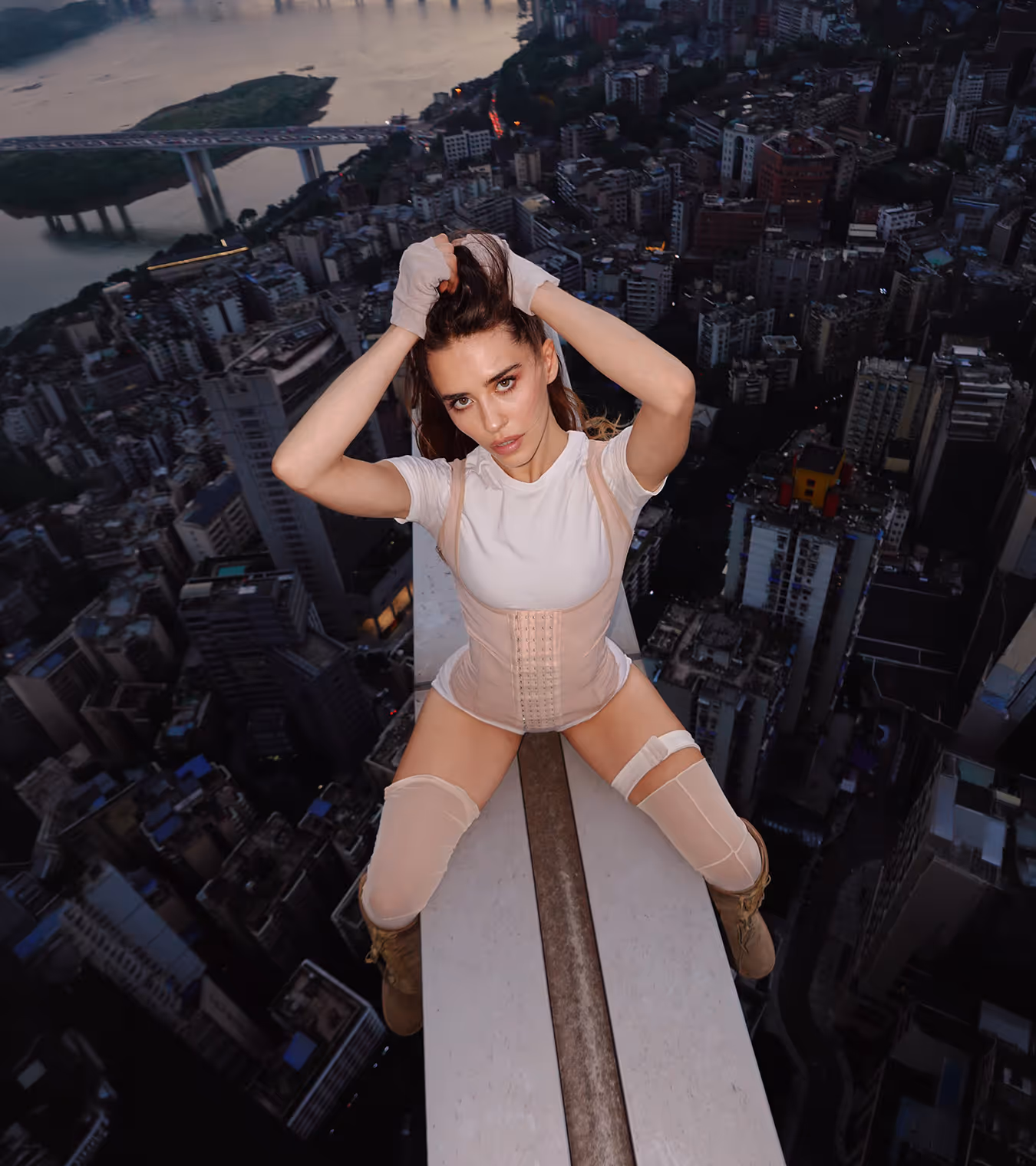 A woman at the edge of a building in a dress.