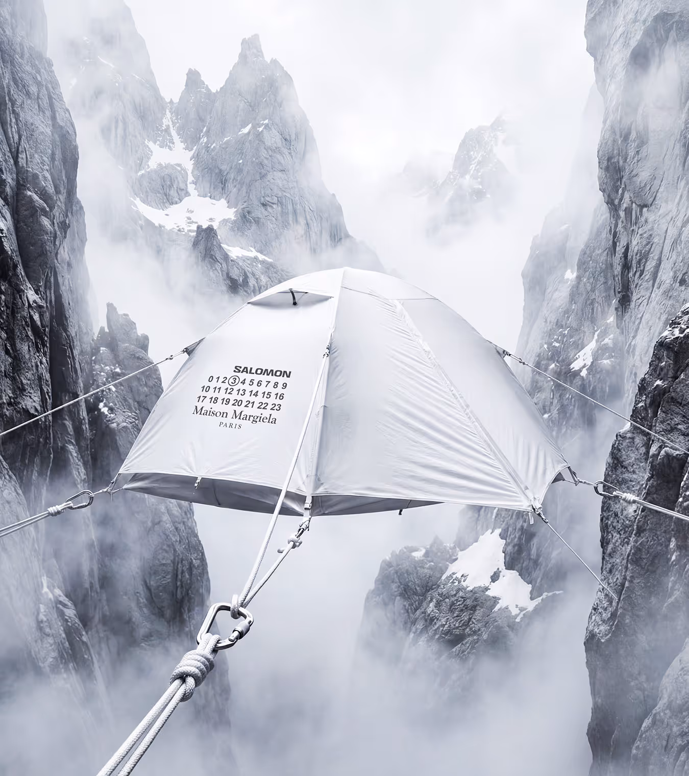 A tent suspended over a crevasse on a snow covered mountain.