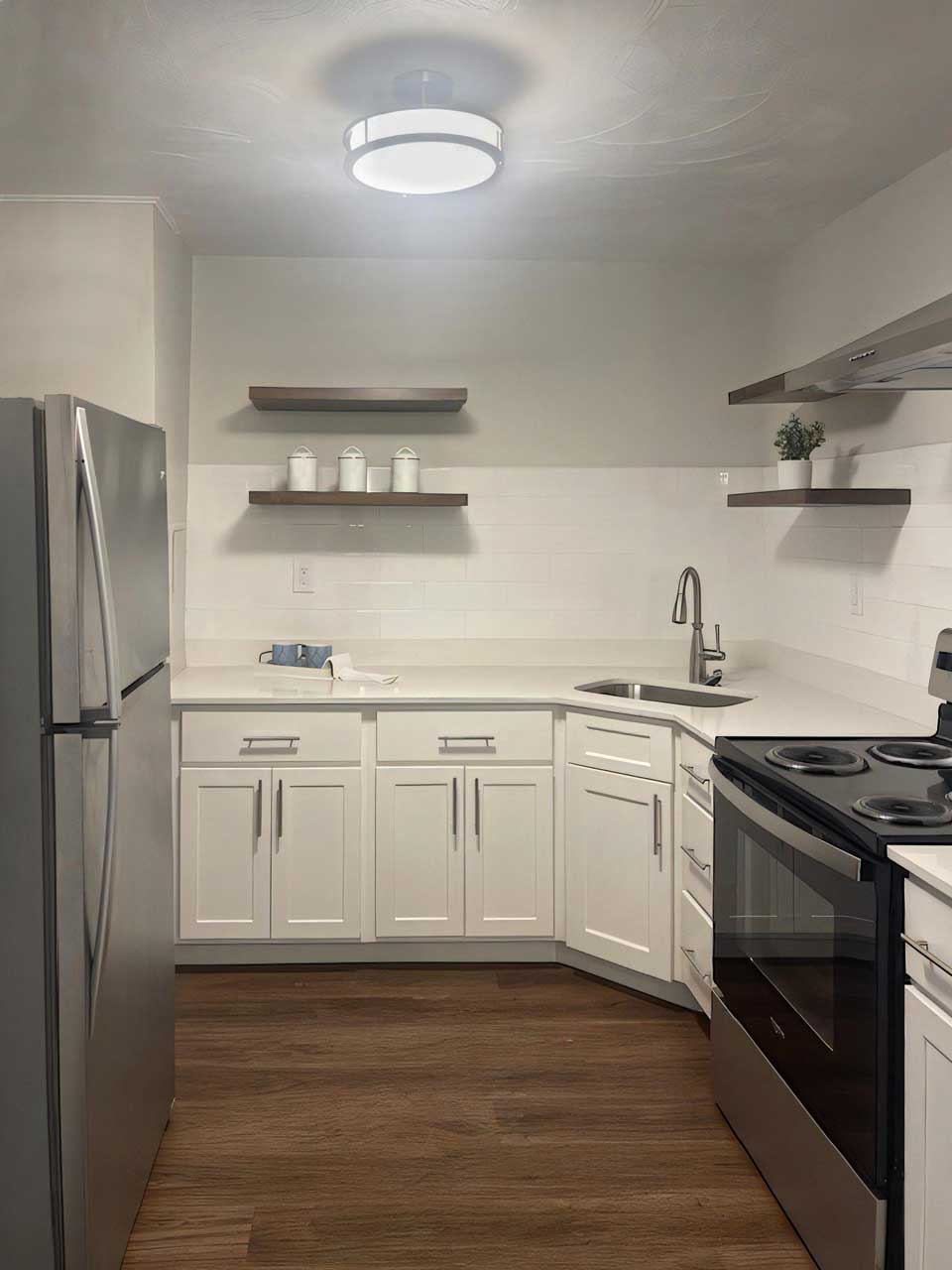 A kitchen with sleek stainless steel appliances and pristine white cabinets, exuding a modern and clean aesthetic.