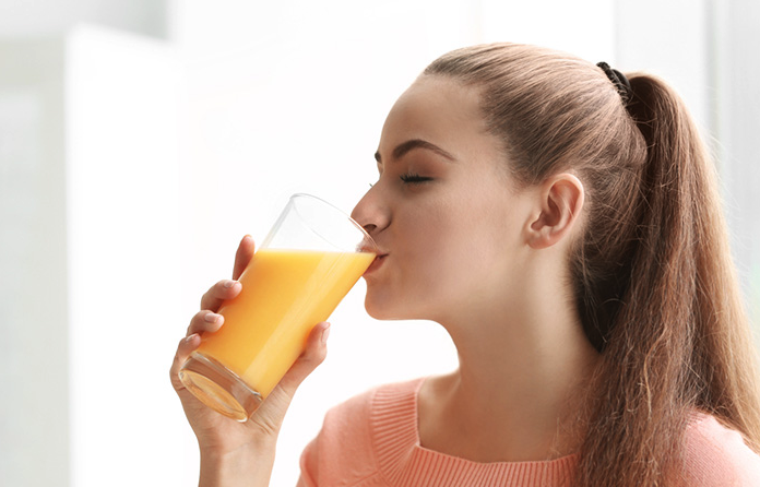 Woman drinking pineapple juice at Coastal Virginia Oral Surgery.