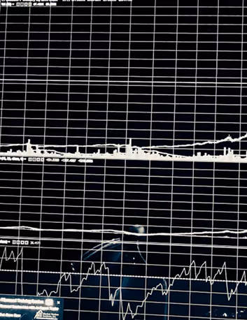 Black screen displaying multiple line graphs and charts with white grid lines and data points.