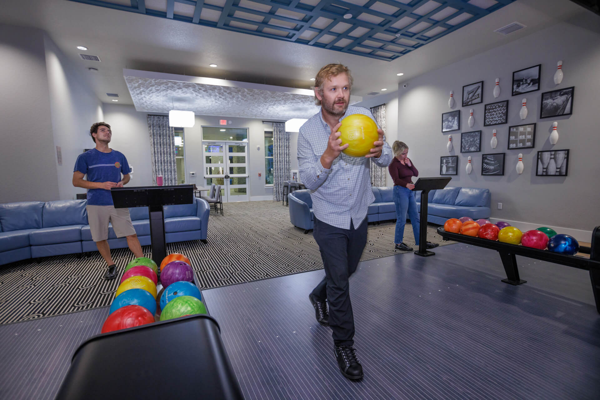 Three bowlers in a private bowling alley Mallory Square apartments in Orlando, Florida.