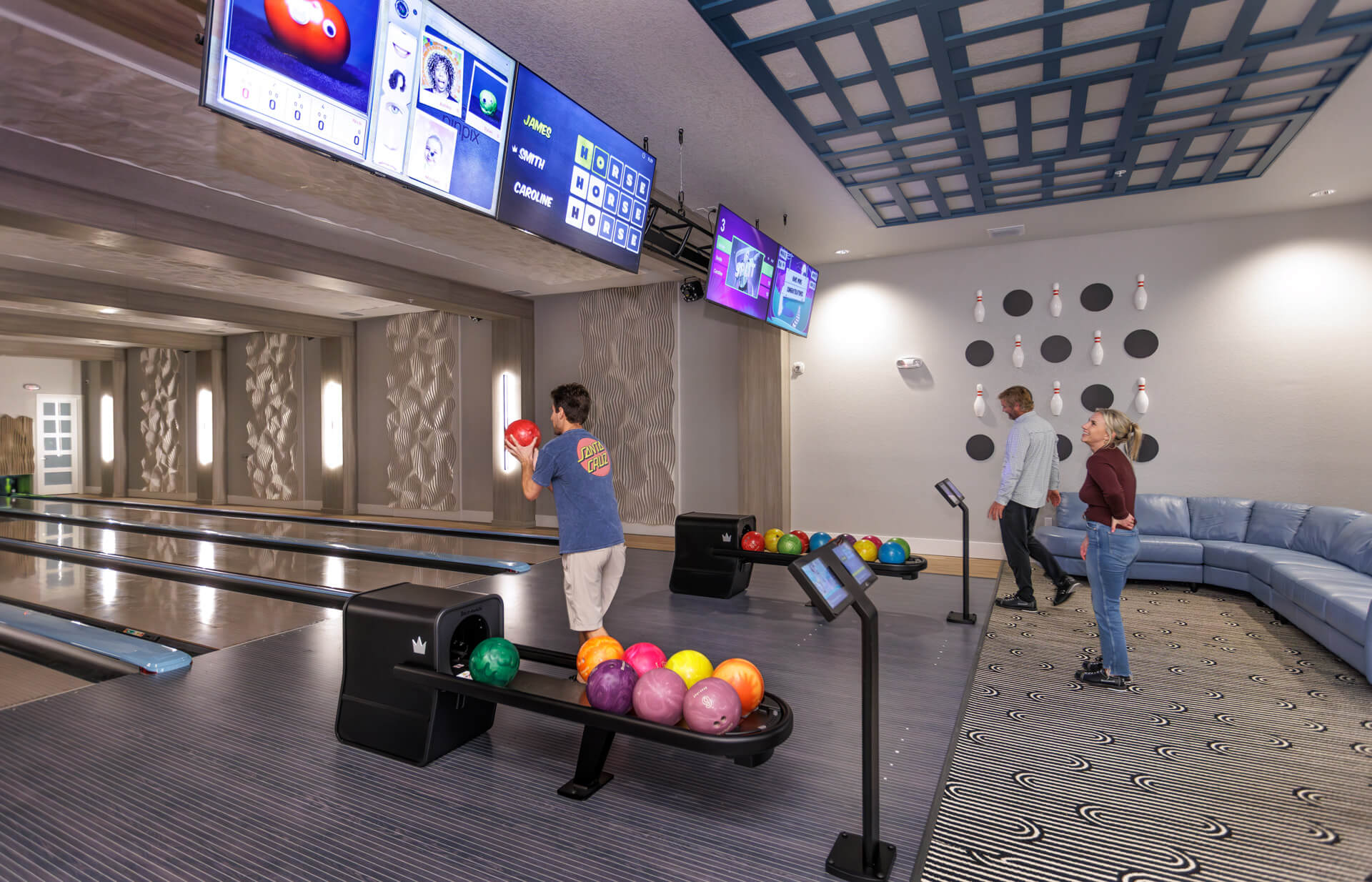 People bowling in a private clubhouse amenity.