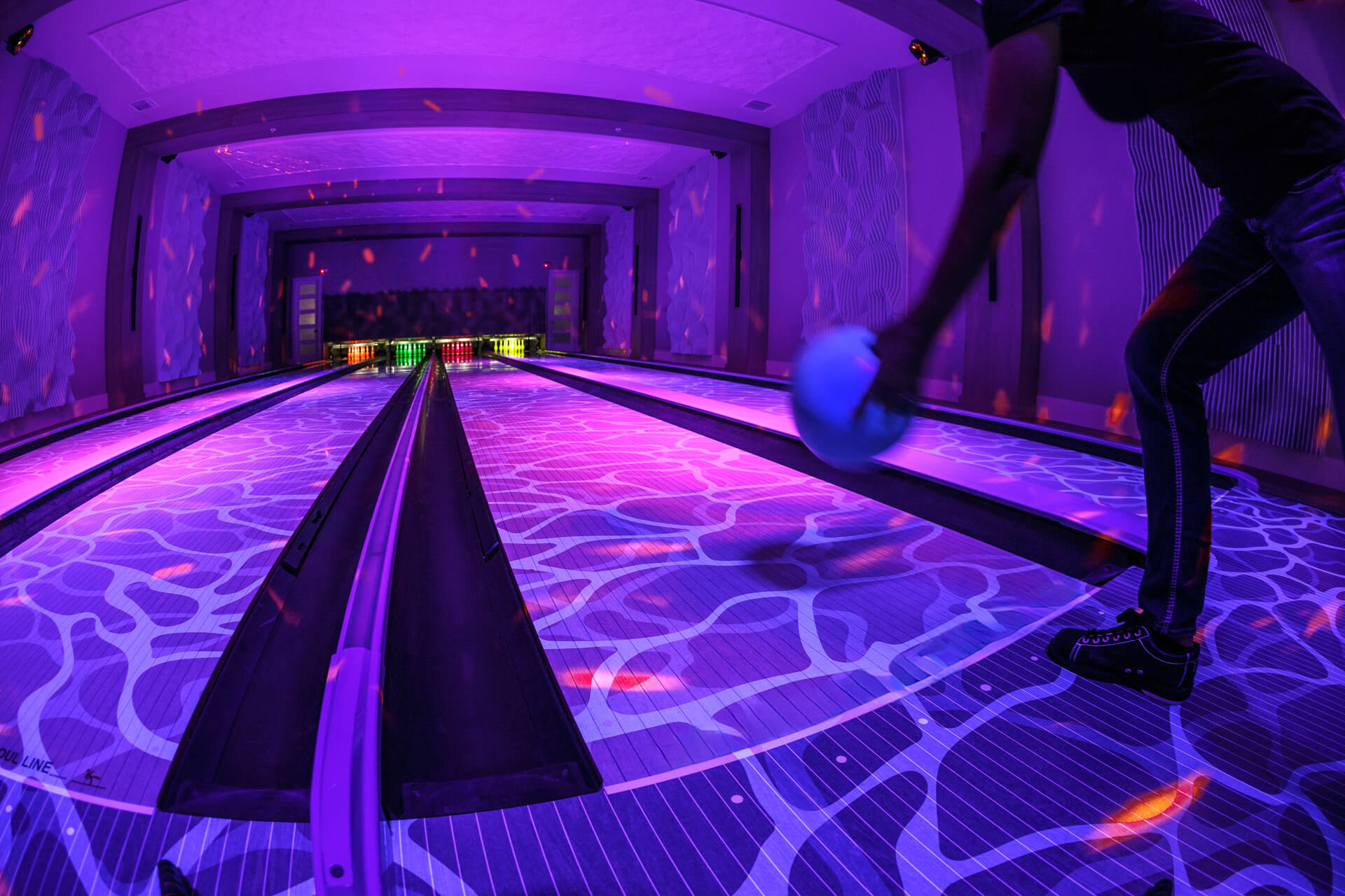 Bowler bowling on a glowing bowling lane with water ripple graphics.