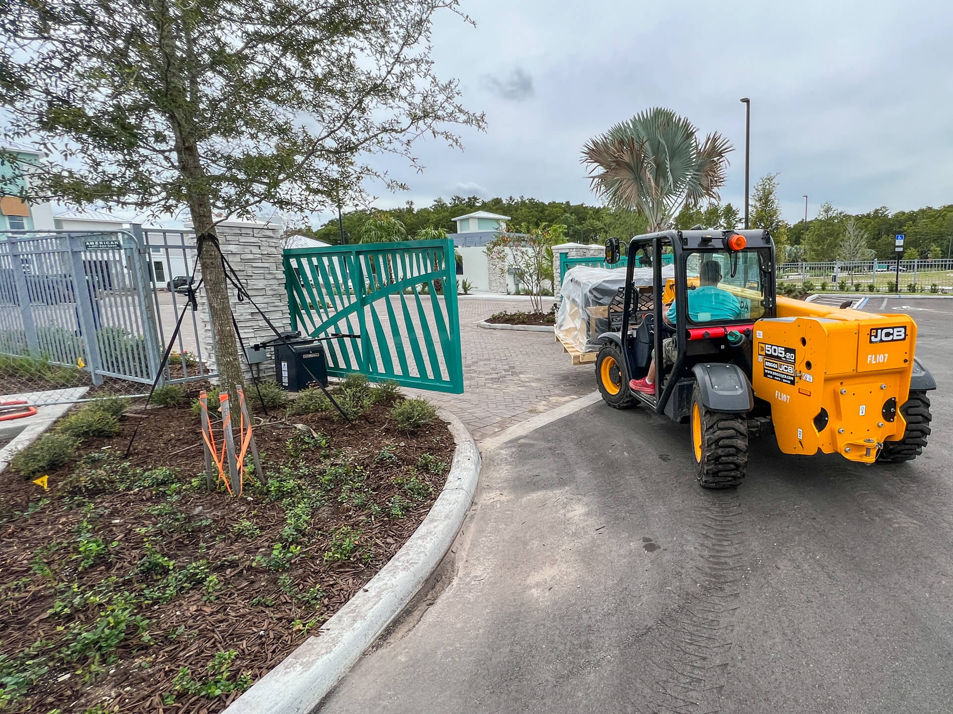 A guy driving a telehandler, carrying bowling alley equipment to the bowling room.