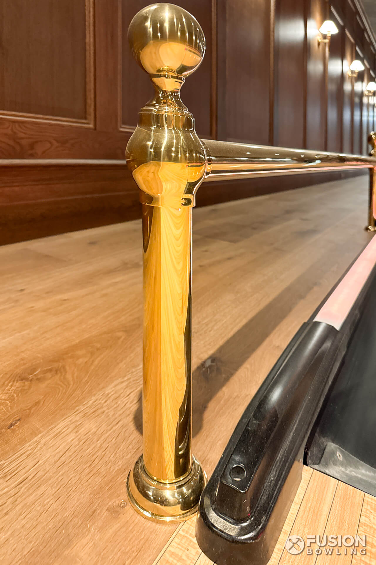 Brass railing next division capping for a bowling alley.