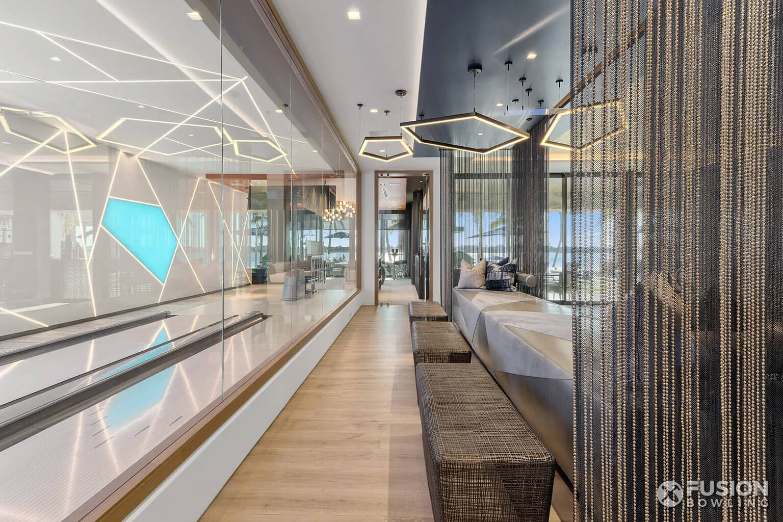 Glass wall next to bowling alley room in a home.