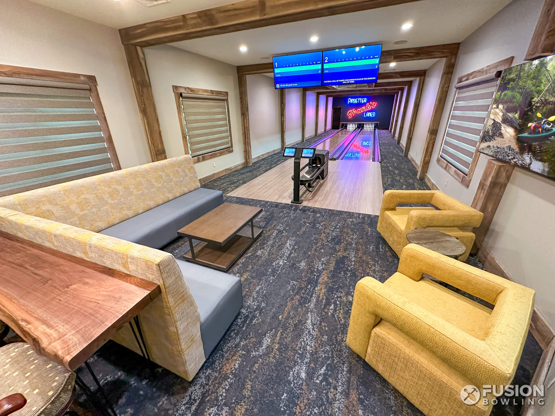 Residential bowling lane equipment with yellow chairs and an L-shaped sofa.