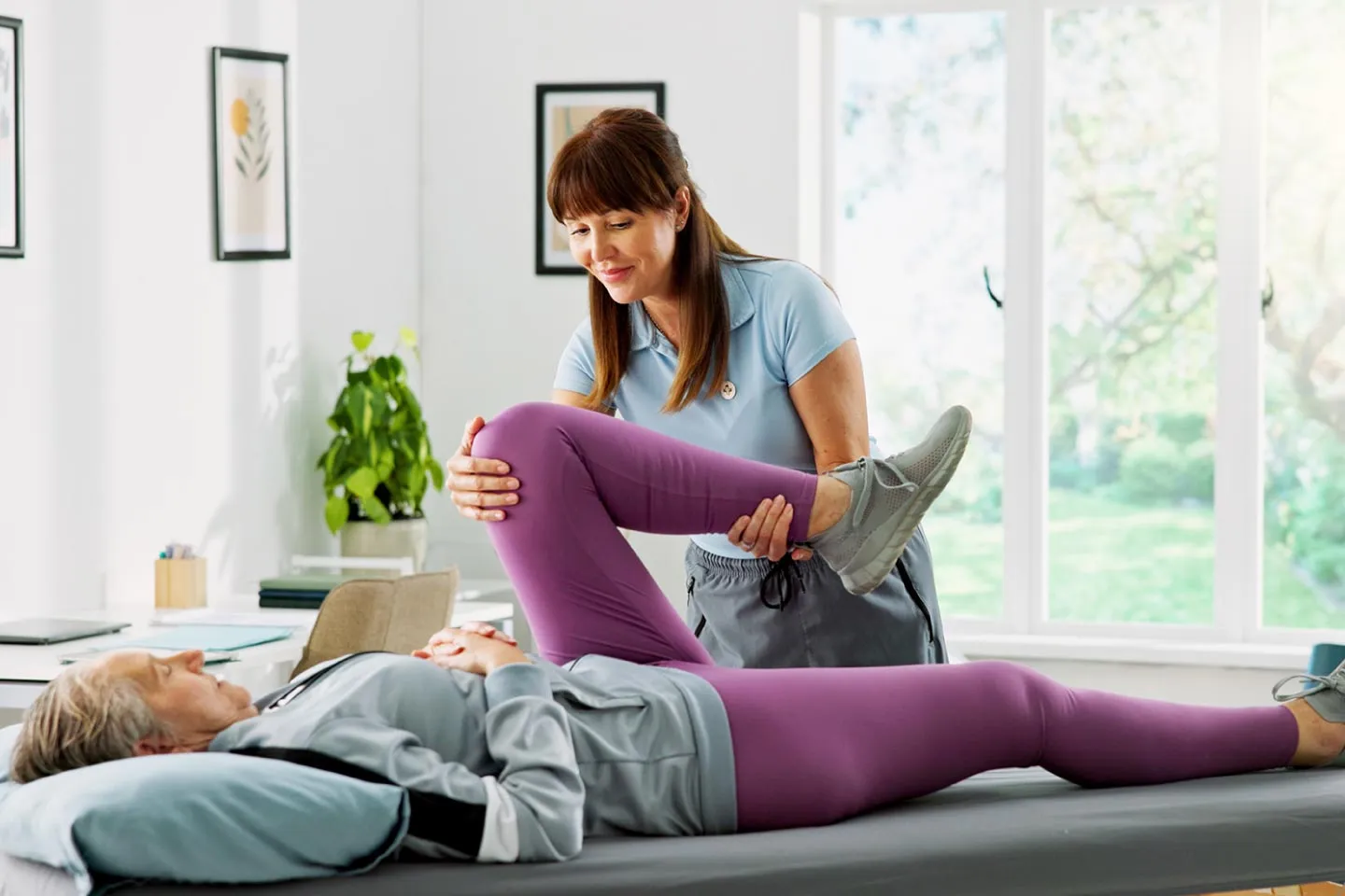 Physical therapist helping a patient with back, knee, or shoulder pain to avoid surgery