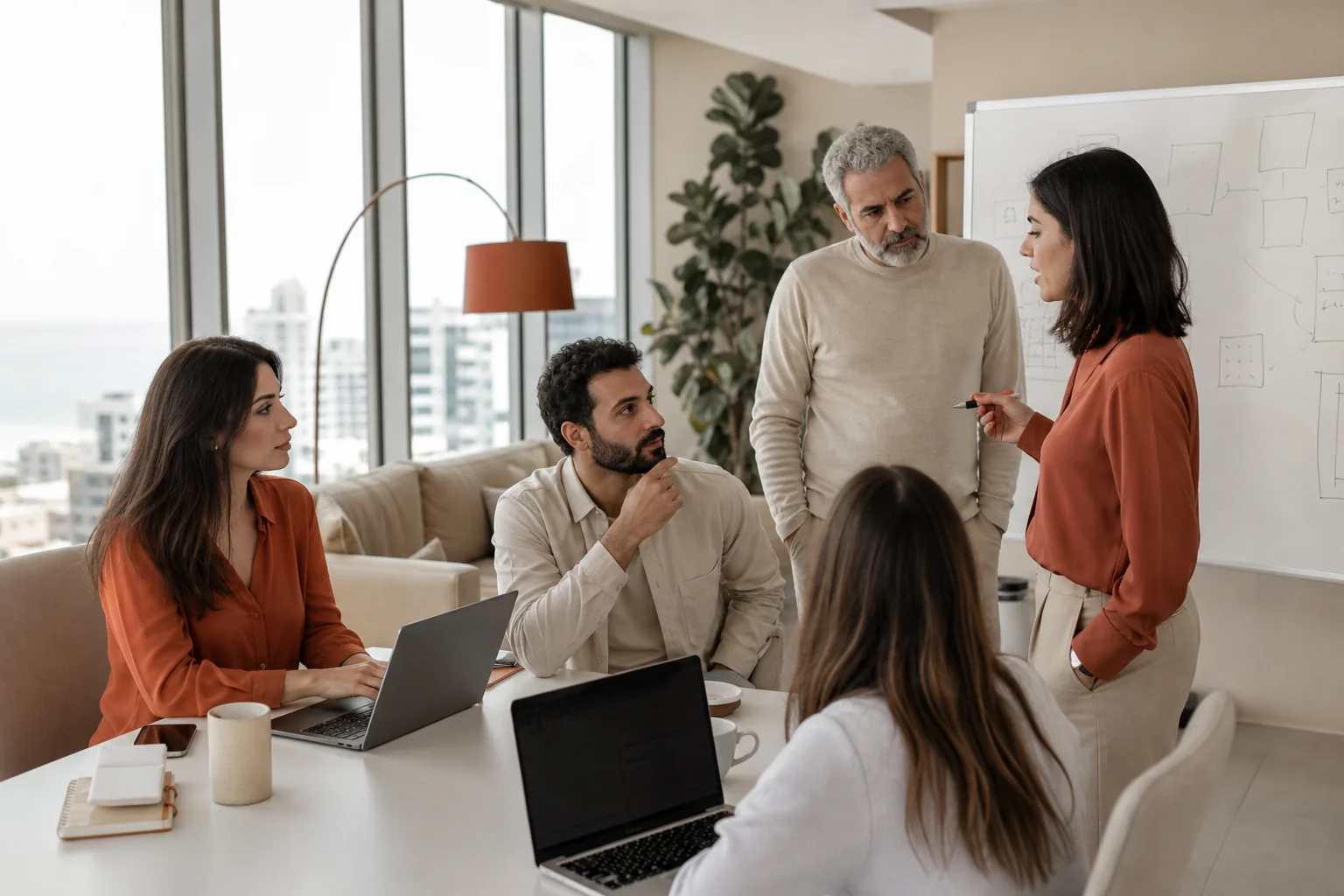 photorealistic photograph of a small team of Lebanese professionals collaborating in a bright modern office in Beirut, mix of ages and genders, laptops and whiteboards with diagrams (no legible text), warm beige and rust accent tones