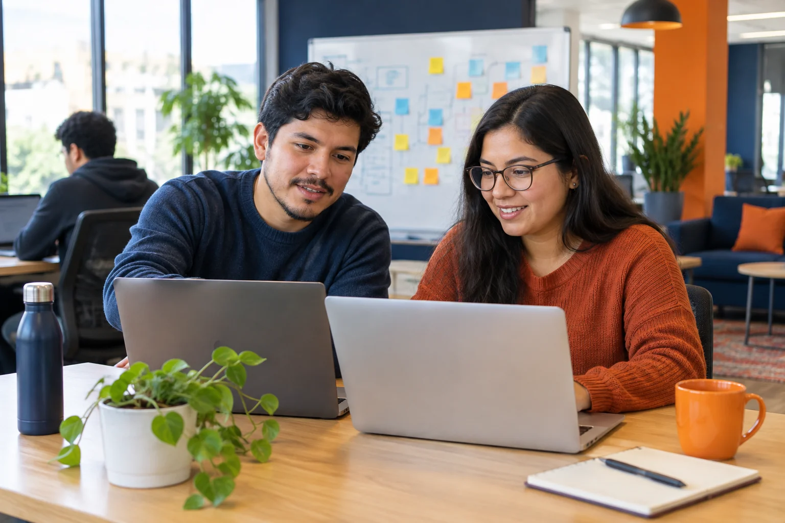 Software engineers collaborating at a nearshore IT office with laptops and whiteboard