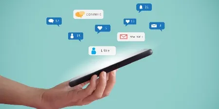 A hand grips a large smartphone, poised against a backdrop of persistent digital notifications symbolized by the array of icons hovering above. This image reflects the constant connectivity of modern work life and underscores the necessity for corporate training on mental wellness, as it highlights the need to manage digital stress for a healthy work-life balance.