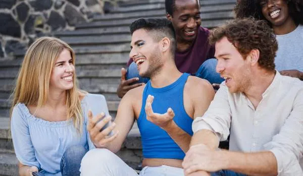 Diverse group of people sitting on stairs outdoors, laughing and smiling