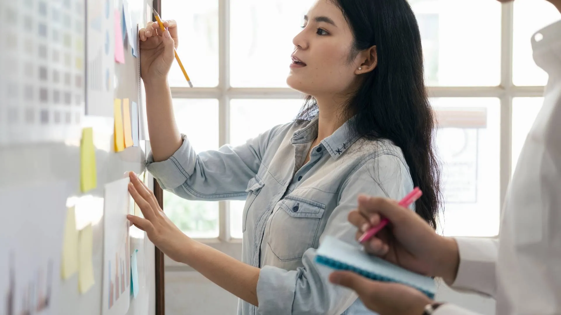 A young woman is working on a whiteboard.