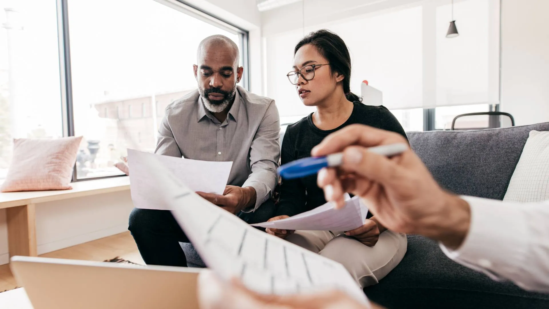 A man and woman sitting on a couch in an office going over a career development plan.