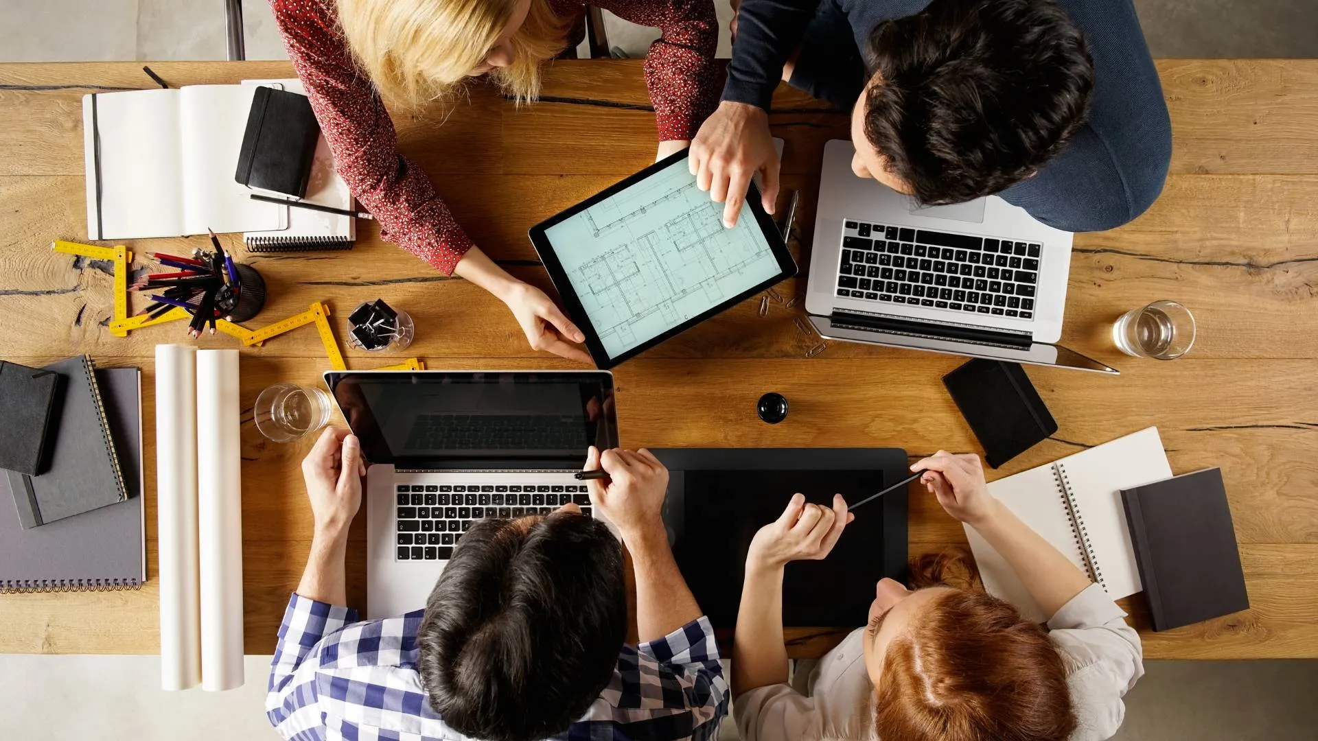 An overhead shot of a team collaborating on a project around a conference table.