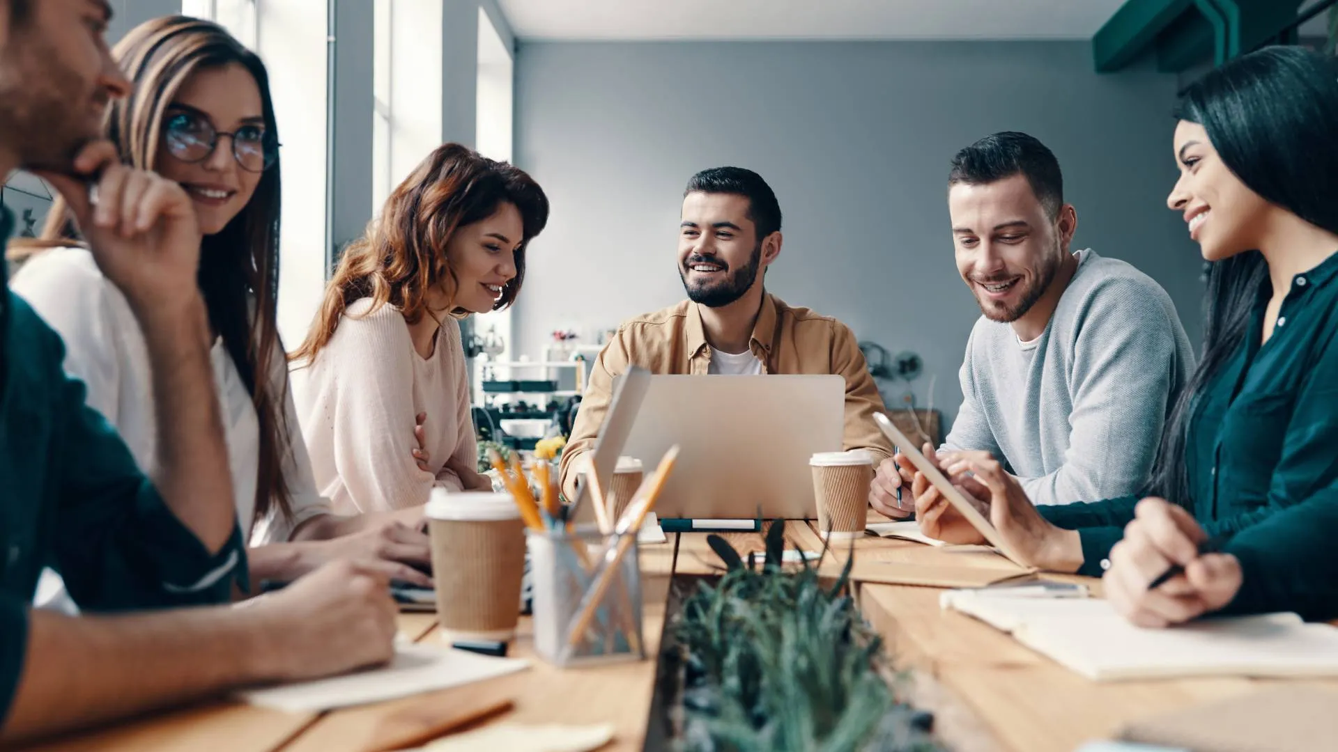 A diverse team is working around a conference table.