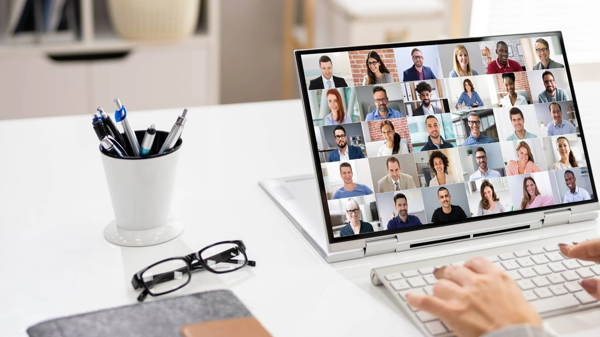 We're looking over someone's shoulder at a virtual all-hands meeting on their laptop.